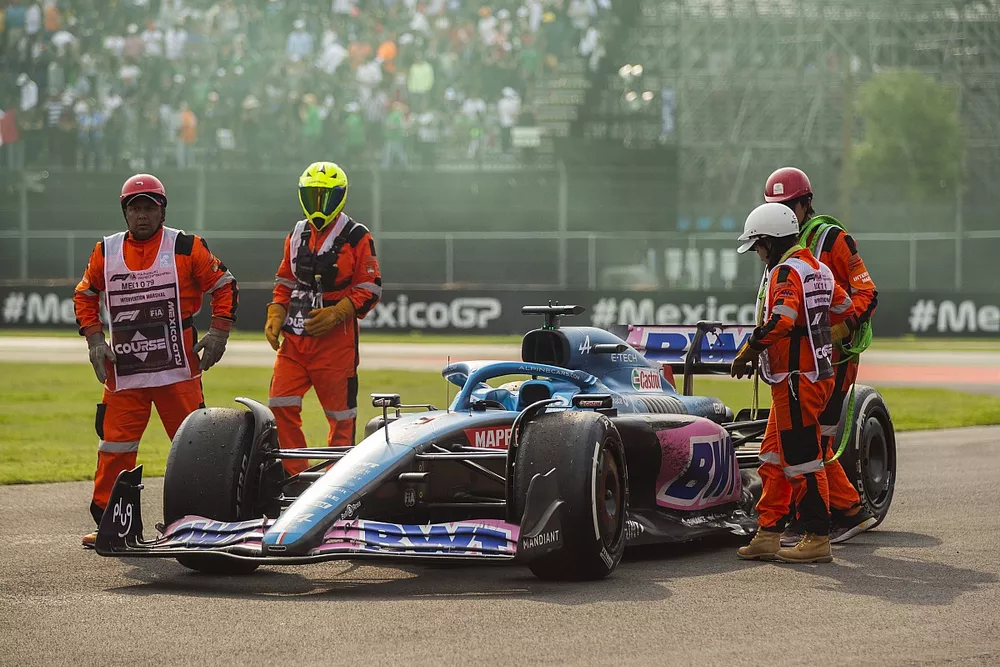Marshals remove the car of Fernando Alonso, Alpine A522, from the circuit