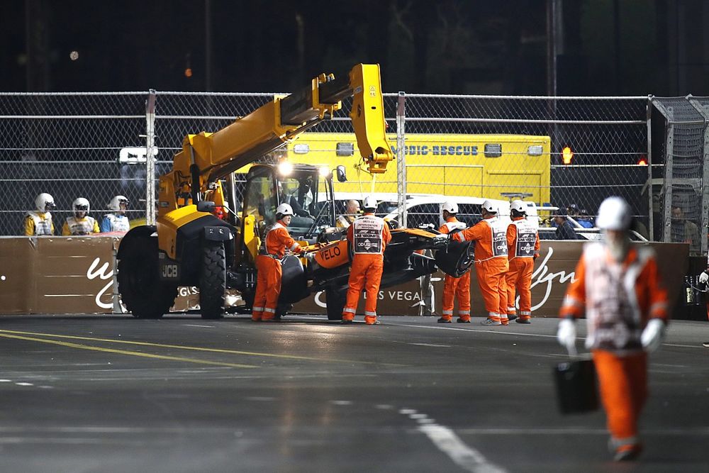 Los oficiales de pista retiran el coche da&ntilde;ado de Lando Norris, McLaren MCL60, del circuito