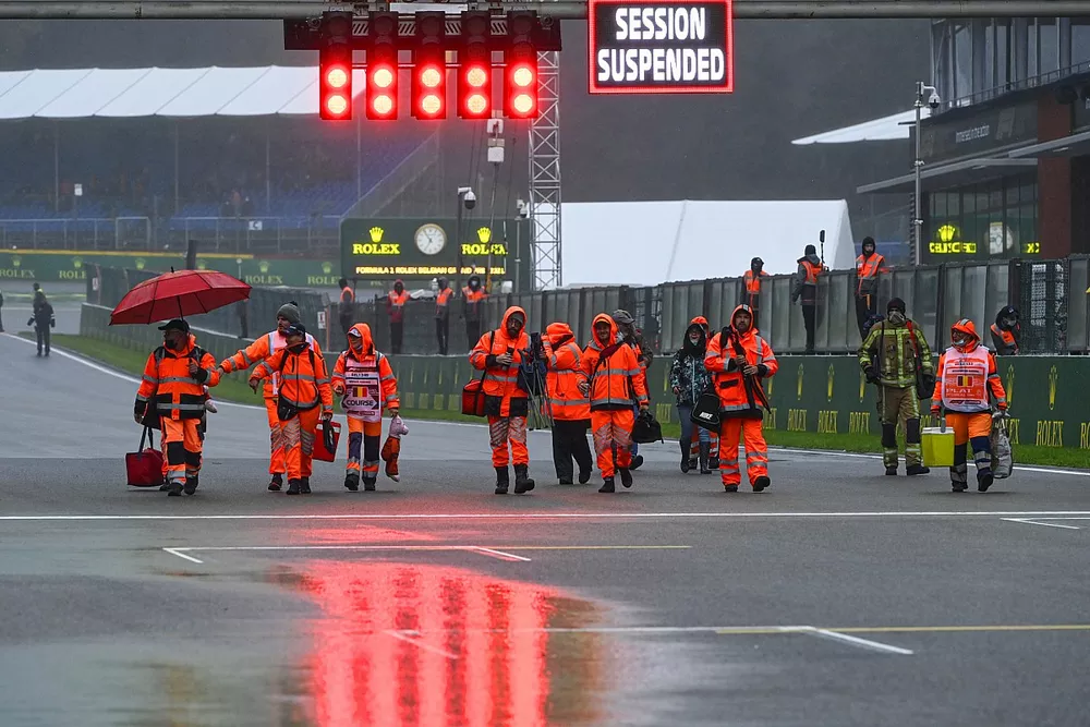 Oficiales de pista y el letrero de sesi&oacute;n suspendida en la parrilla