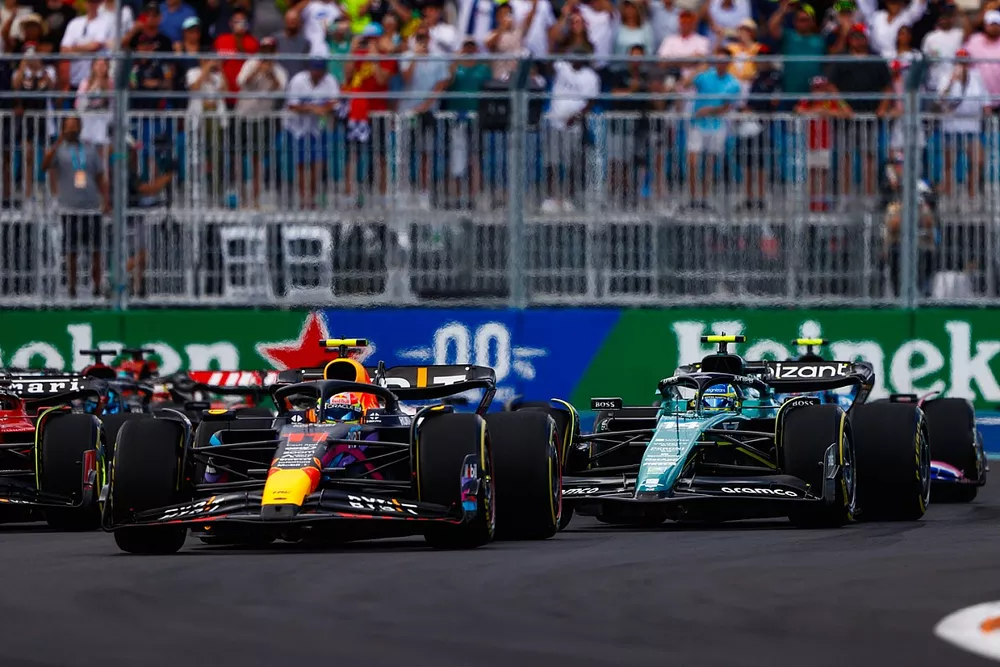 Sergio Pérez, Red Bull Racing RB19, Fernando Alonso, Aston Martin AMR23, el resto de la parrilla en la primera vuelta.