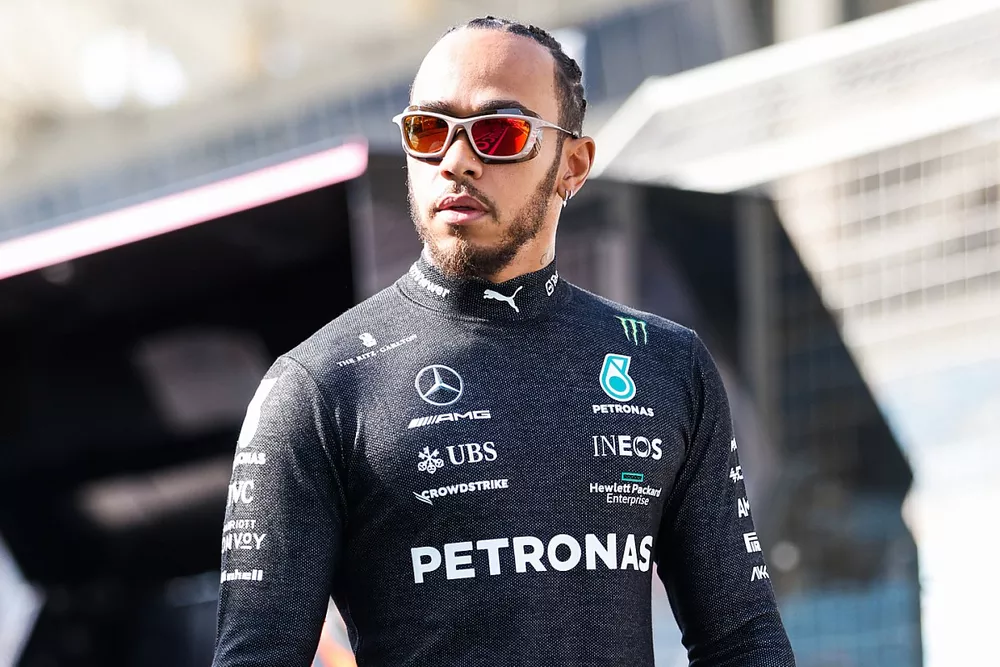 Lewis Hamilton, Mercedes-AMG, carries his crash helmet in the pit lane