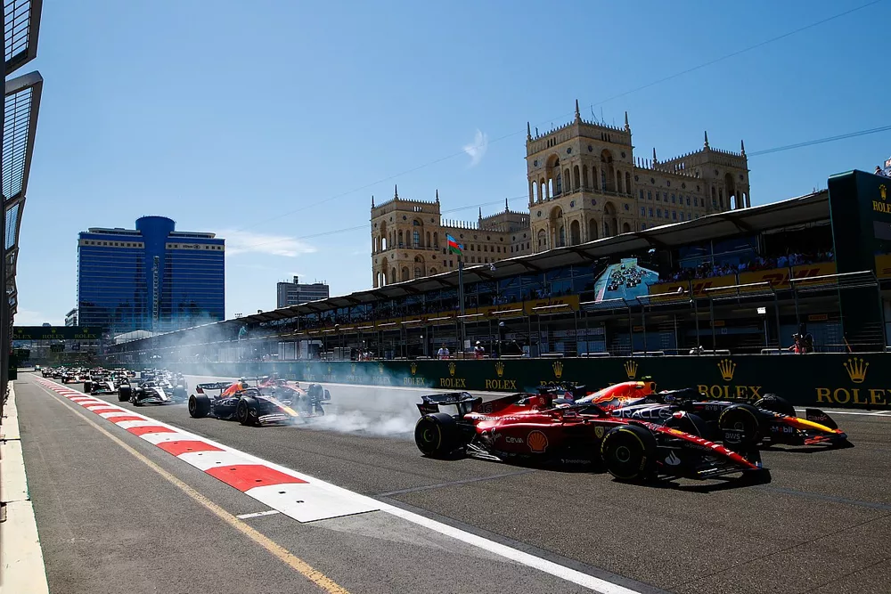 Arrancada Sergio P&eacute;rez, Red Bull Racing RB18, adelanta a Charles Leclerc, Ferrari F1-75 por el liderato en la salida. Max Verstappen, Red Bull Racing RB18 y Carlos Sainz, Ferrari F1-75 en la primera curva