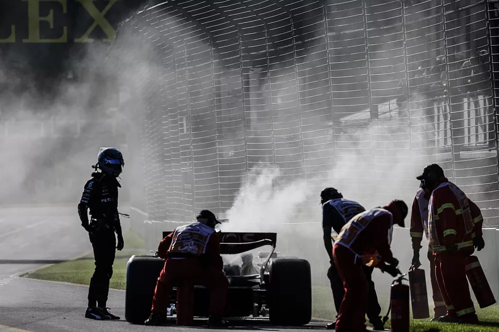 Marshals use extinguishers on the car of George Russell, Mercedes F1 W14