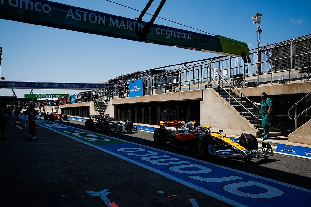 Oscar Piastri, McLaren MCL60, Lewis Hamilton, Mercedes F1 W14, en el pit lane