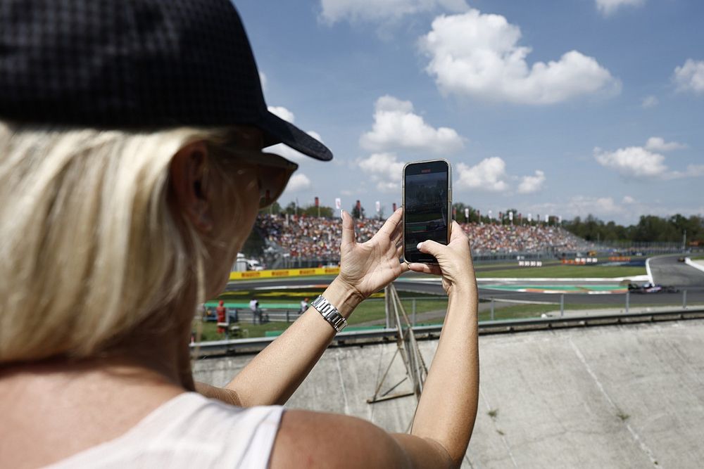 Una fan toma una foto al paso de Pierre Gasly, Alpine A523