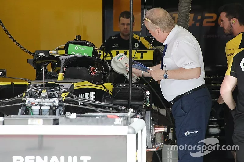 FIA delegate Jo Bauer uses a device to scan multiple chips that can be used to acquire data about the Renault F1 Team chassis