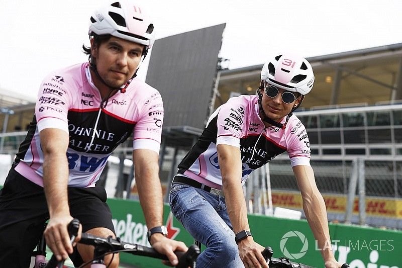 Esteban Ocon, Force India y Sergio Pérez, Force India, andan por el circuito en bicicleta