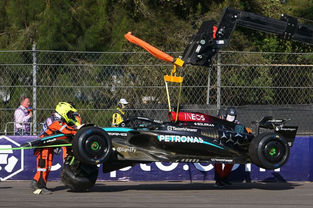Marshals clear away the car of George Russell, Mercedes F1 W15 