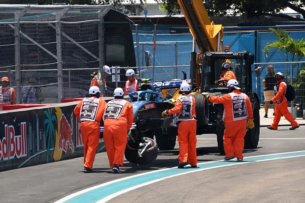 Los oficiales de pista retiran el coche da&ntilde;ado de Esteban Ocon, Alpine A522, tras un accidente