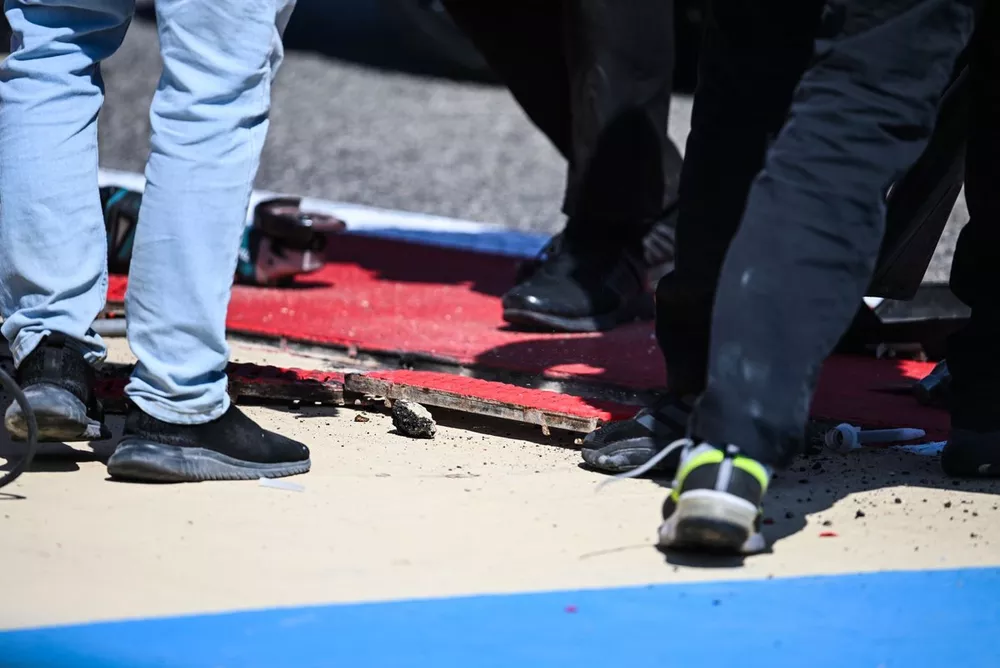 Marshalls and Race control work to fix a loose drain cover