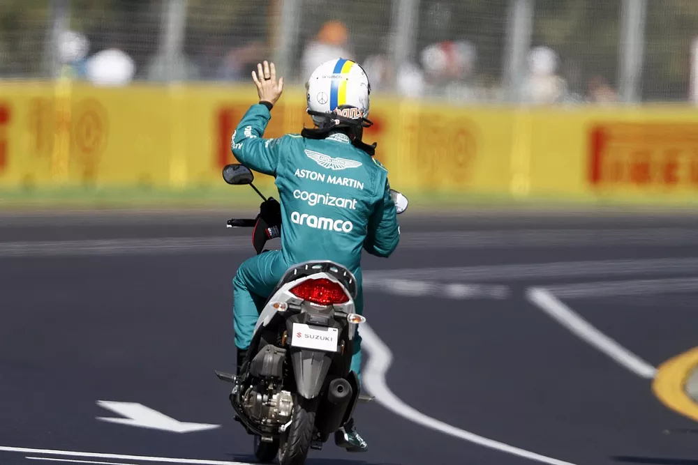 Sebastian Vettel, Aston Martin, gets a ride back to the pits