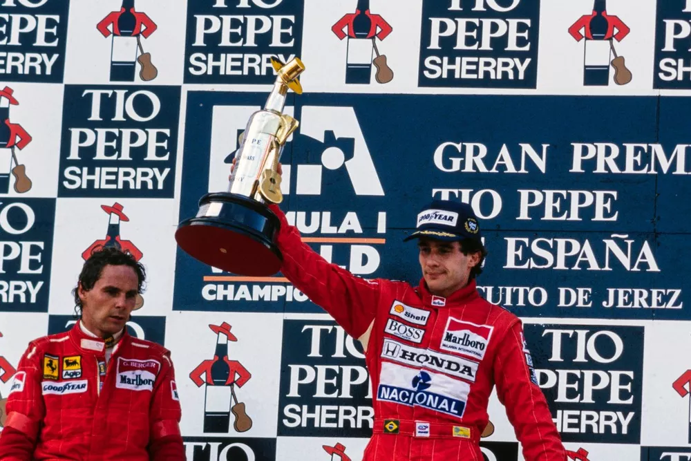 Ayrton Senna, 1e positie, Gerhard Berger, 2e positie, en Alain Prost, 3e positie, op het podium. Senna heft zijn trofee.