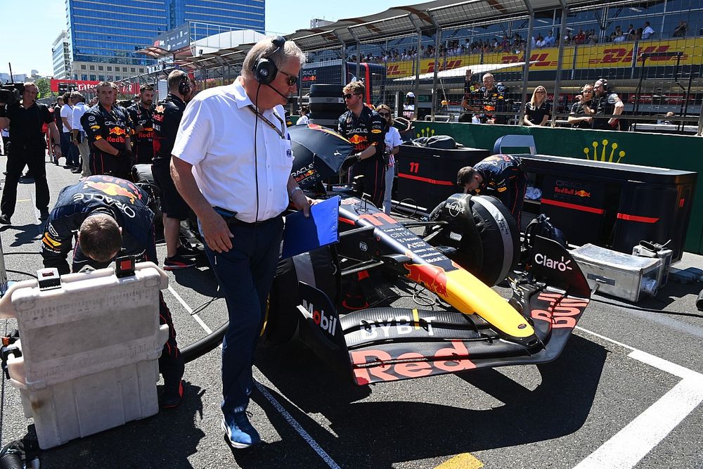 Un funcionario de la FIA en la parrilla con el coche de Sergio Pérez, Red Bull Racing RB18