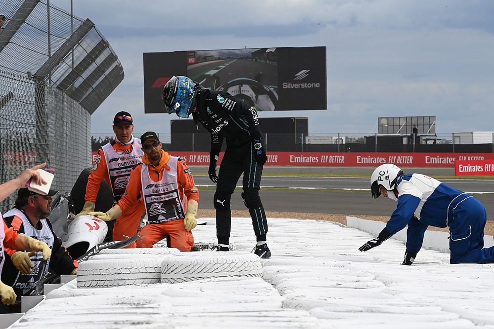 George Russell, Mercedes-AMG, assists marshals in extracting Zhou Guanyu, Alfa Romeo F1 Team, from his car