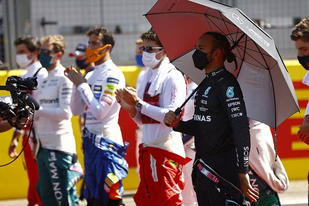 Lewis Hamilton, Mercedes, and the other drivers stand on the grid for the national anthem
