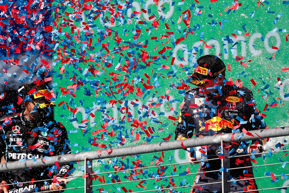Lewis Hamilton, Mercedes, 2nd position, and Max Verstappen, Red Bull Racing, 1st position, spray Champagne on the podium