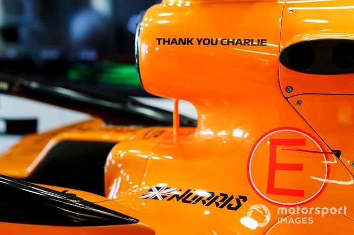 Coche de Lando Norris, McLaren MCL34 en el garaje con un gráfico de agradecimiento en memoria de Charlie Whiting