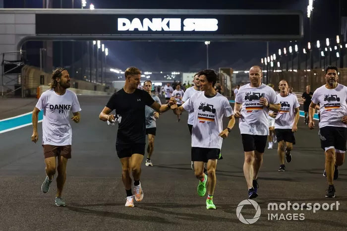 Sebastian Vettel, Aston Martin, es acompañado en una carrera alrededor del circuito por Mick Schumacher, Haas F1 Team, Jack Aitken, miembros de su equipo y simpatizantes como parte de su despedida en su último Gran Premio