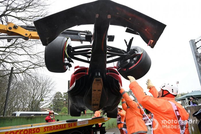 Oficiales de pista cargan el coche de Carlos Sainz Jr., Ferrari F1-75, en una grúa
