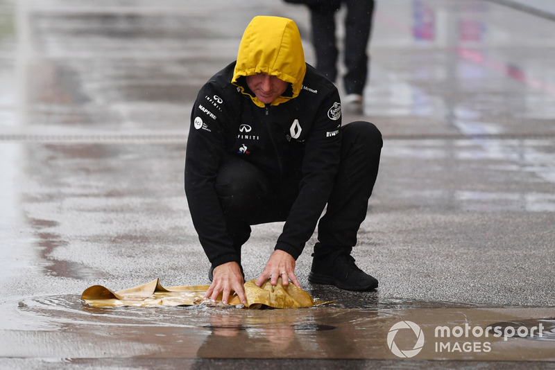 Un meccanico Renault Sport F1 Team con un panno di camoscio, asciuga la piazzola box