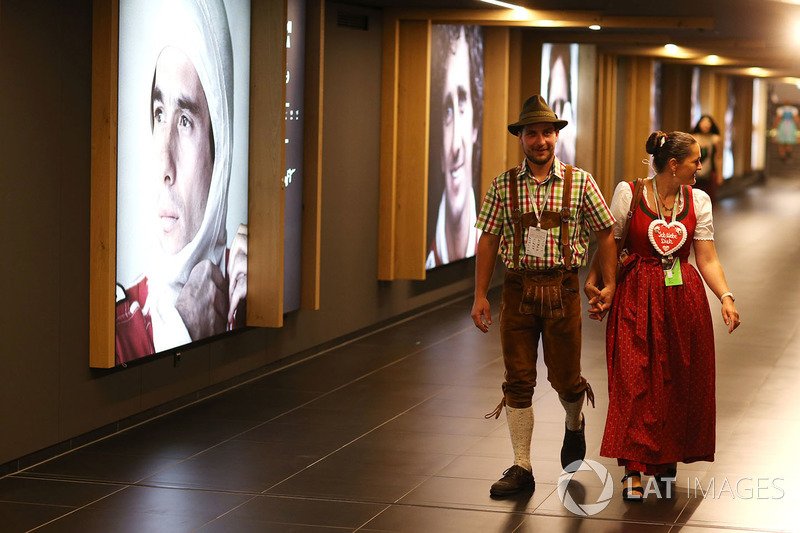 Traditionally dressed fans walk past a gallery of world champions