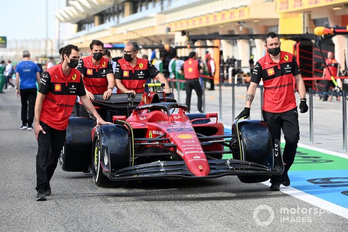 Carlos Sainz Jr., Ferrari F1-75 y miembros del equipo en el pit lane