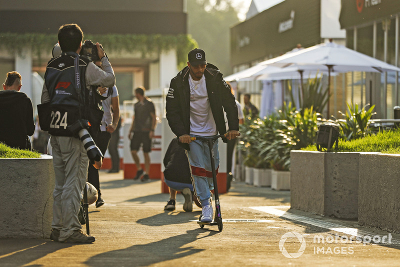 Lewis Hamilton, Mercedes AMG F1, rides his scooter through the paddock 