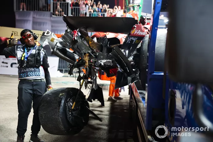 Un comisario con el coche dañado de Carlos Sainz, Ferrari SF-24, en un camión