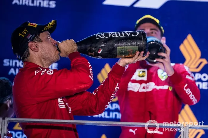 Sebastian Vettel, Ferrari, primo classificato, e Charles Leclerc, Ferrari, secondo classificato, beve Champagne sul podio