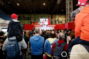 Una gran multitud se reúne para escuchar al presentador Stuart Codling entrevistando a Charles Leclerc, Ferrari en el escenario de Autosport