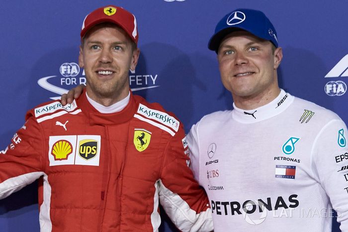 Ganador de la pole Sebastian Vettel, Ferrari, con Valtteri Bottas, Mercedes AMG F1