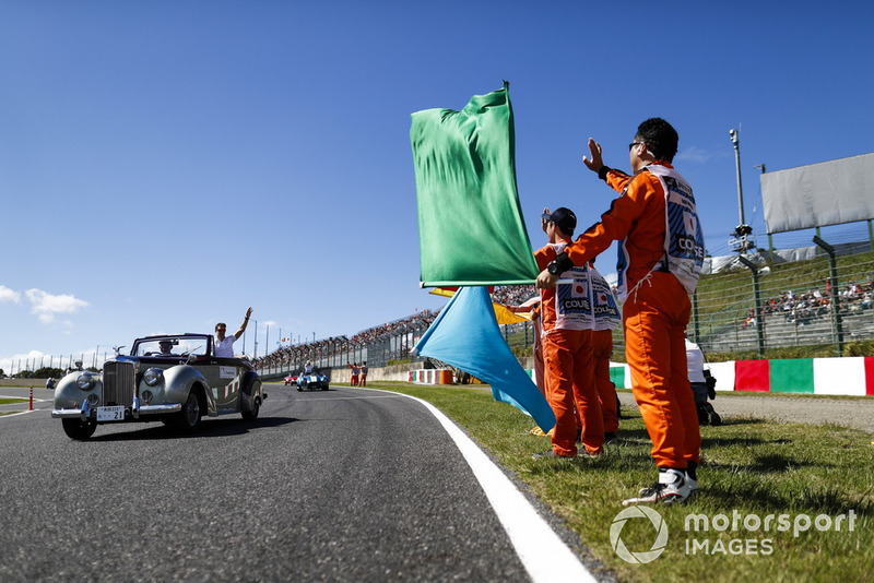 Des commissaires regardent Stoffel Vandoorne, McLaren, passer lors de la parade des pilotes