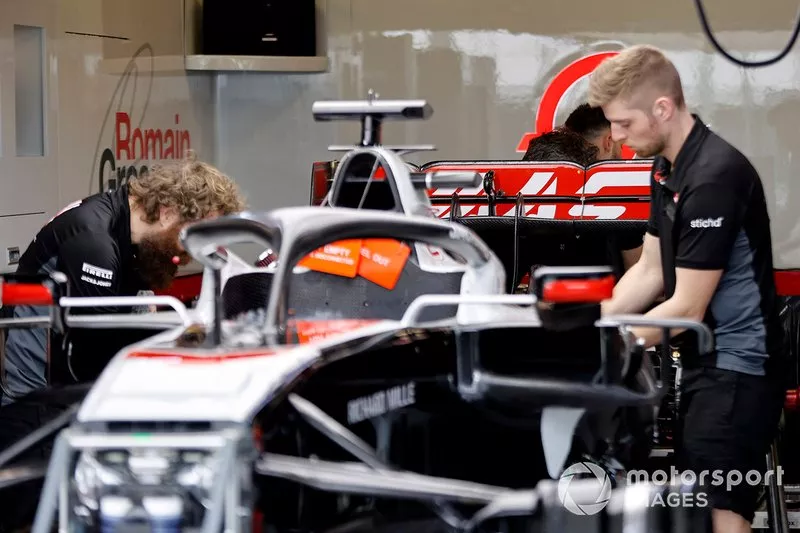 Los mecánicos de Haas trabajan en su coche en el garaje