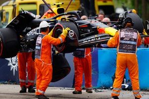 Los comisarios retiran el coche dañado de Sergio Pérez, Red Bull Racing RB20