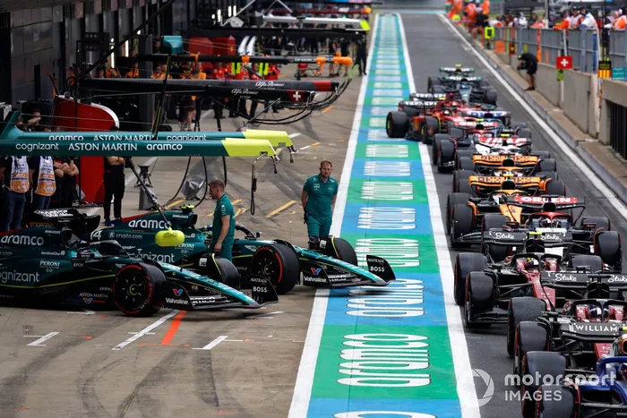 Lance Stroll, Aston Martin AMR23, Fernando Alonso, Aston Martin AMR23, esperan para unirse a la cola para salir de boxes durante la Calificación.