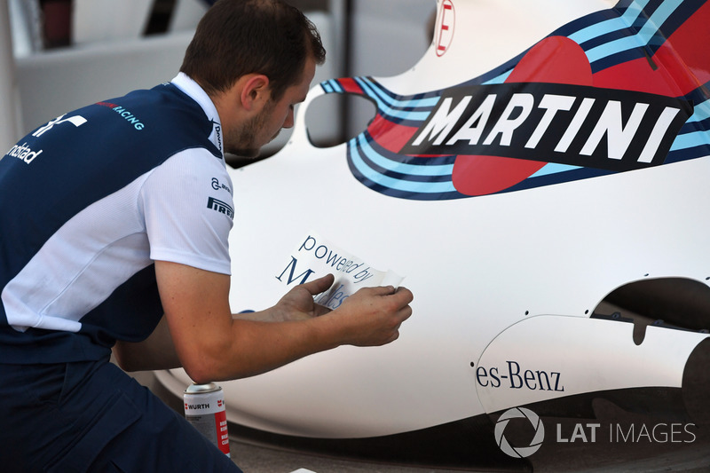 Механік Williams наліплює лого на боковий понтон Williams FW40