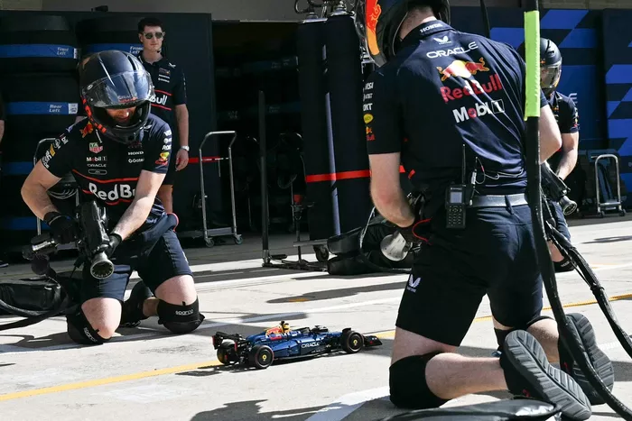 Red Bull Racing crew members perform a pit stop with a LEGO car     