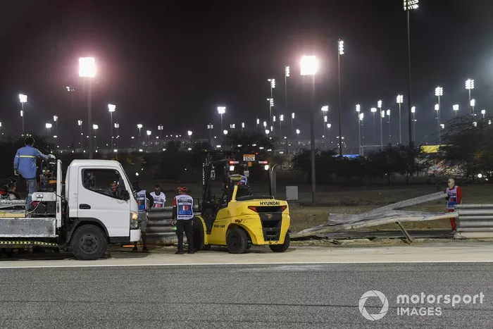 Los oficiales retiran los restos después del choque de Romain Grosjean, Haas VF-20, en la primera vuelta