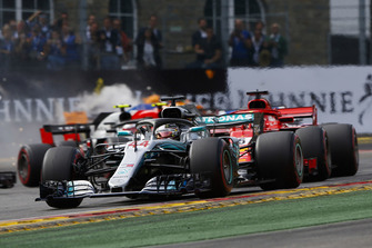Lewis Hamilton, Mercedes AMG F1 W09, leads Sebastian Vettel, Ferrari SF71H, and the remainder of the field as Fernando Alonso, McLaren MCL33, crashes out in the background