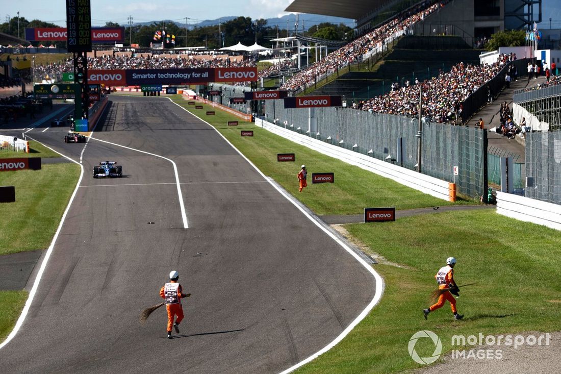 Esteban Ocon, Alpine A523, Valtteri Bottas, Alfa Romeo C43, salen de boxes mientras los comisarios barren la pista