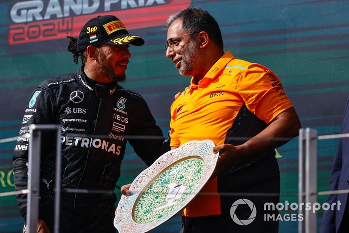 Lewis Hamilton, Mercedes-AMG F1 Team, 3ª posición, conversa con el delegado de trofeos de McLaren en el podio.