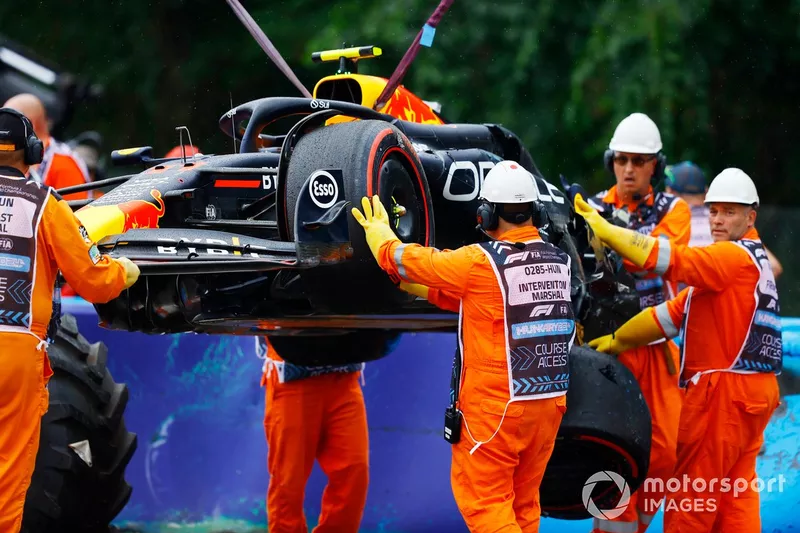 Les commissaires retirent la voiture endommagée de Sergio Perez, Red Bull Racing RB20