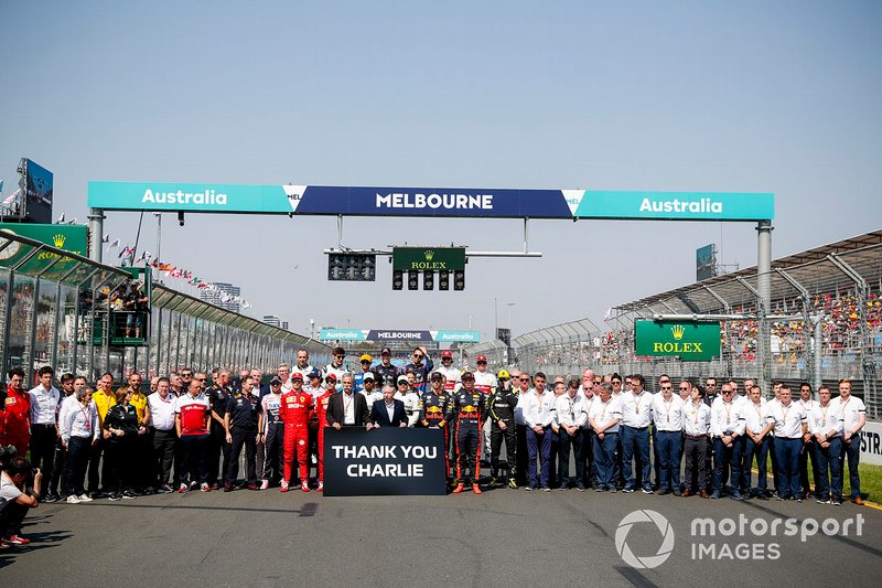Los pilotos y el personal del equipo se reúnen detrás de Chase Carey, Presidente, Fórmula 1 y Jean Todt, Presidente, FIA, que sostienen un cartel que recuerda a Charlie Whiting.
