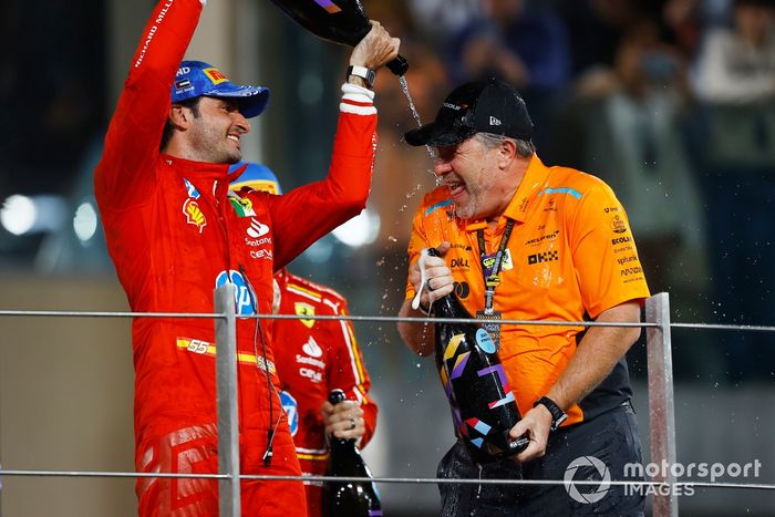 Carlos Sainz, Scuderia Ferrari, 2. miejsce, nalewa szampana Zakowi Brownowi, dyrektorowi generalnemu McLaren Racing, na podium.