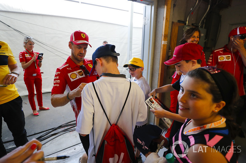 Sebastian Vettel, Ferrari, signs autographs for grid kids