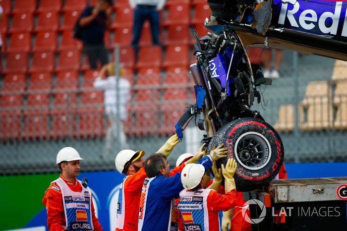 Marshals remove the damaged car of Brendon Hartley, Toro Rosso STR13, from the circuit as the gearbox hangs off the back