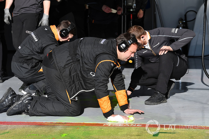 Mekanik McLaren membersihkan cat aeropaint dari lantai garasi