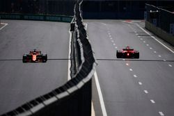 Fernando Alonso, McLaren MCL32, Kimi Raikkonen, Ferrari SF70H, drive down opposing sides of a carriageway