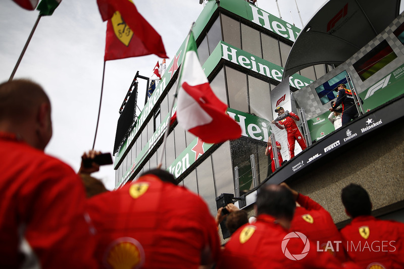 Sebastian Vettel, Ferrari, 1st position, and Max Verstappen, Red Bull Racing, 3rd position, spray Champagne on the podium