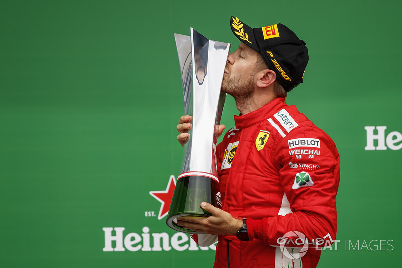 Sebastian Vettel, Ferrari, 1st position, celebrates by kissing his trophy on the podium